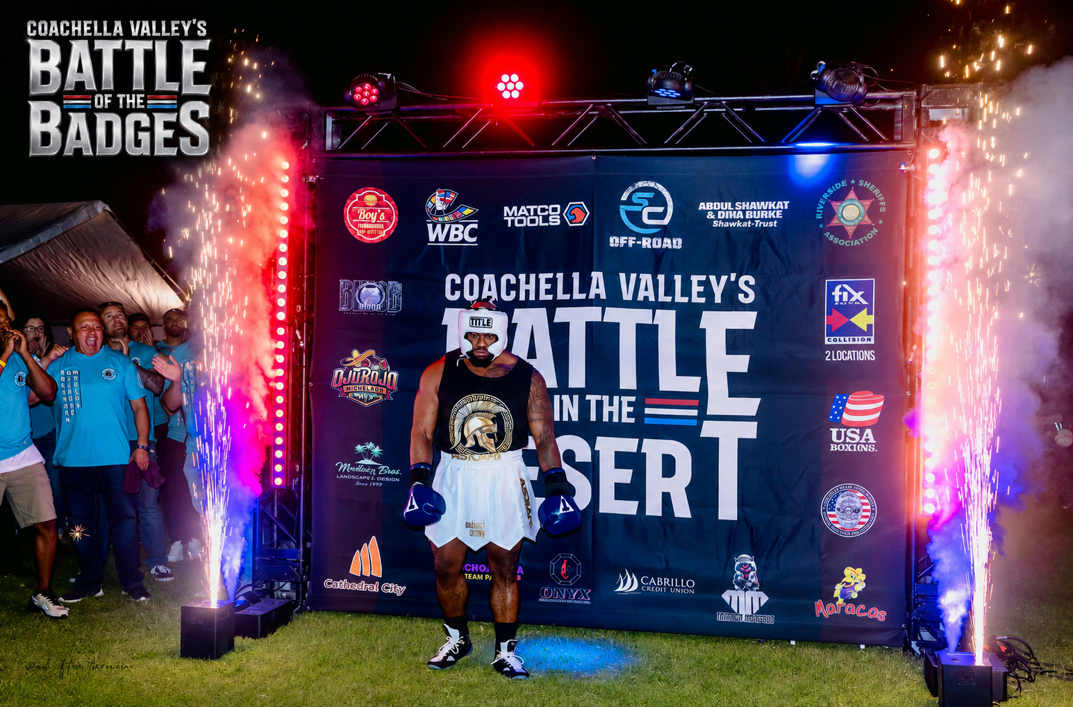 A boxer standing at the Battle of the Badges entrance with red and blue sparks